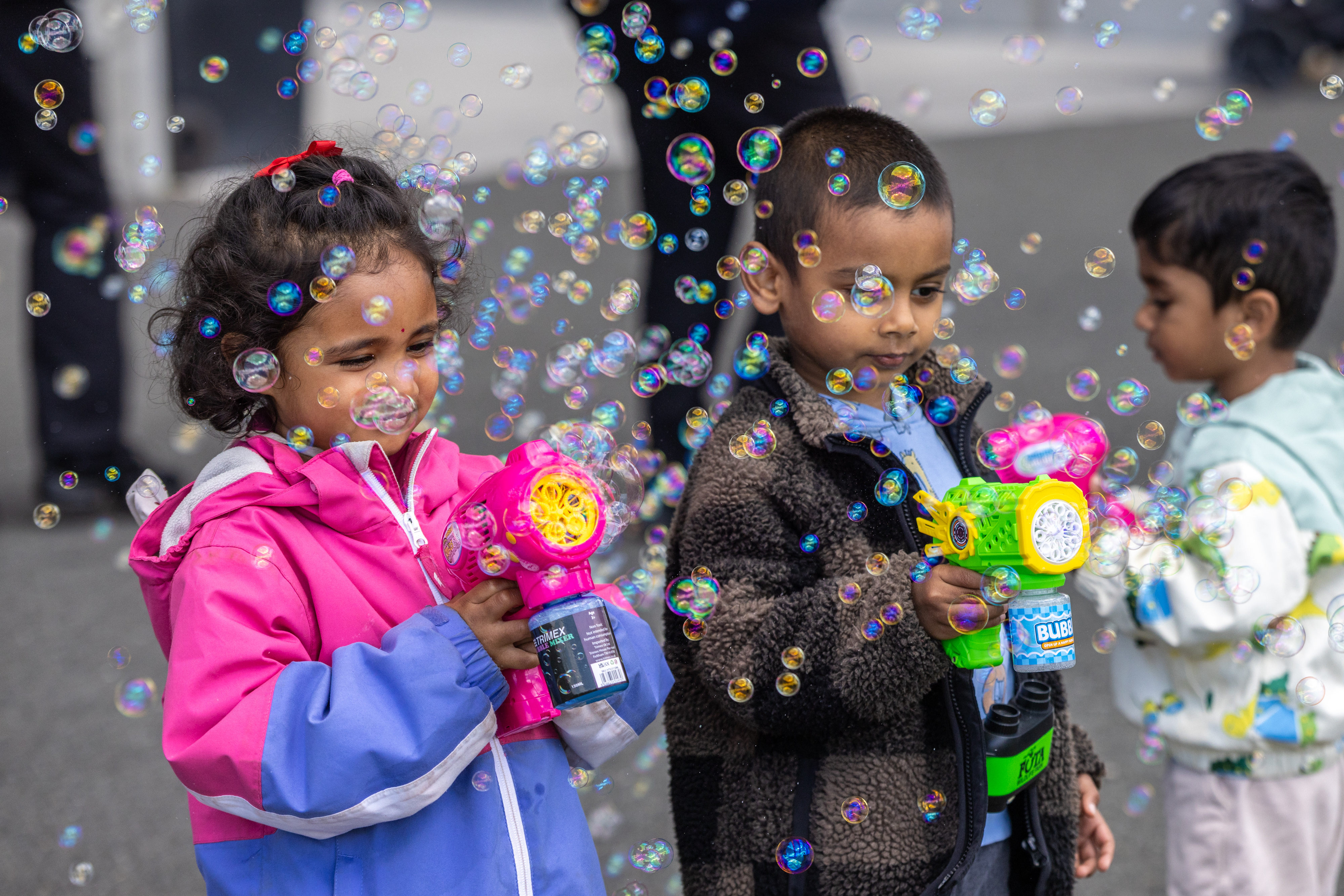 Three children Playing with bubbles 